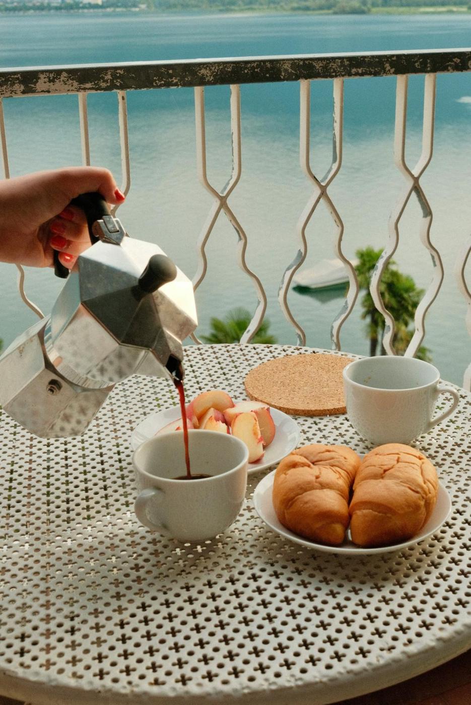 Coffee poured for two on a balcony overlooking a lake